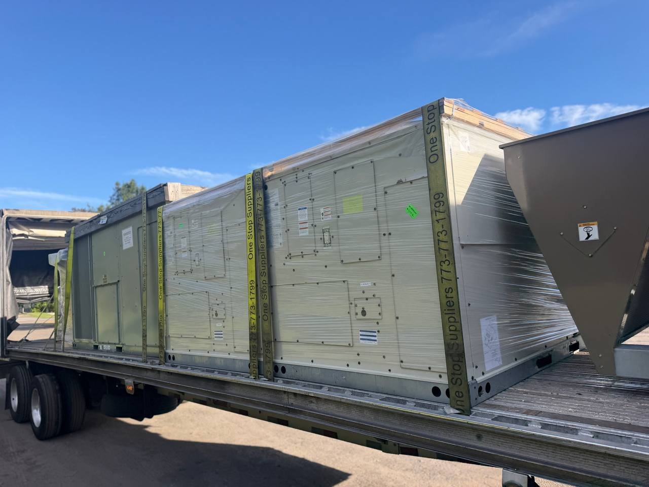 Shrink-wrapped HVAC units strapped on a trailer