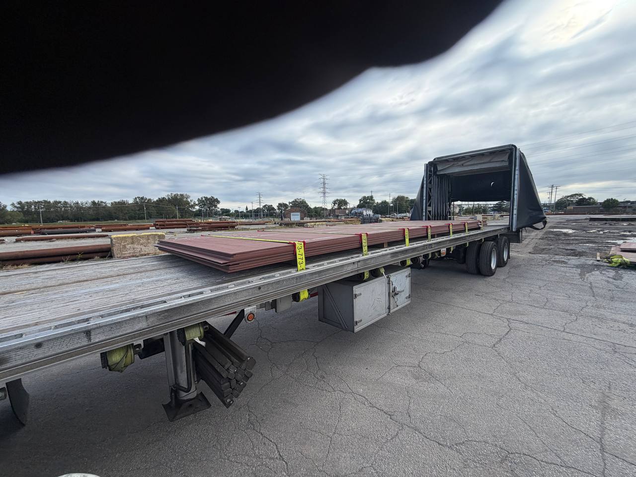 Stack of steel plates strapped on a Conestoga trailer
