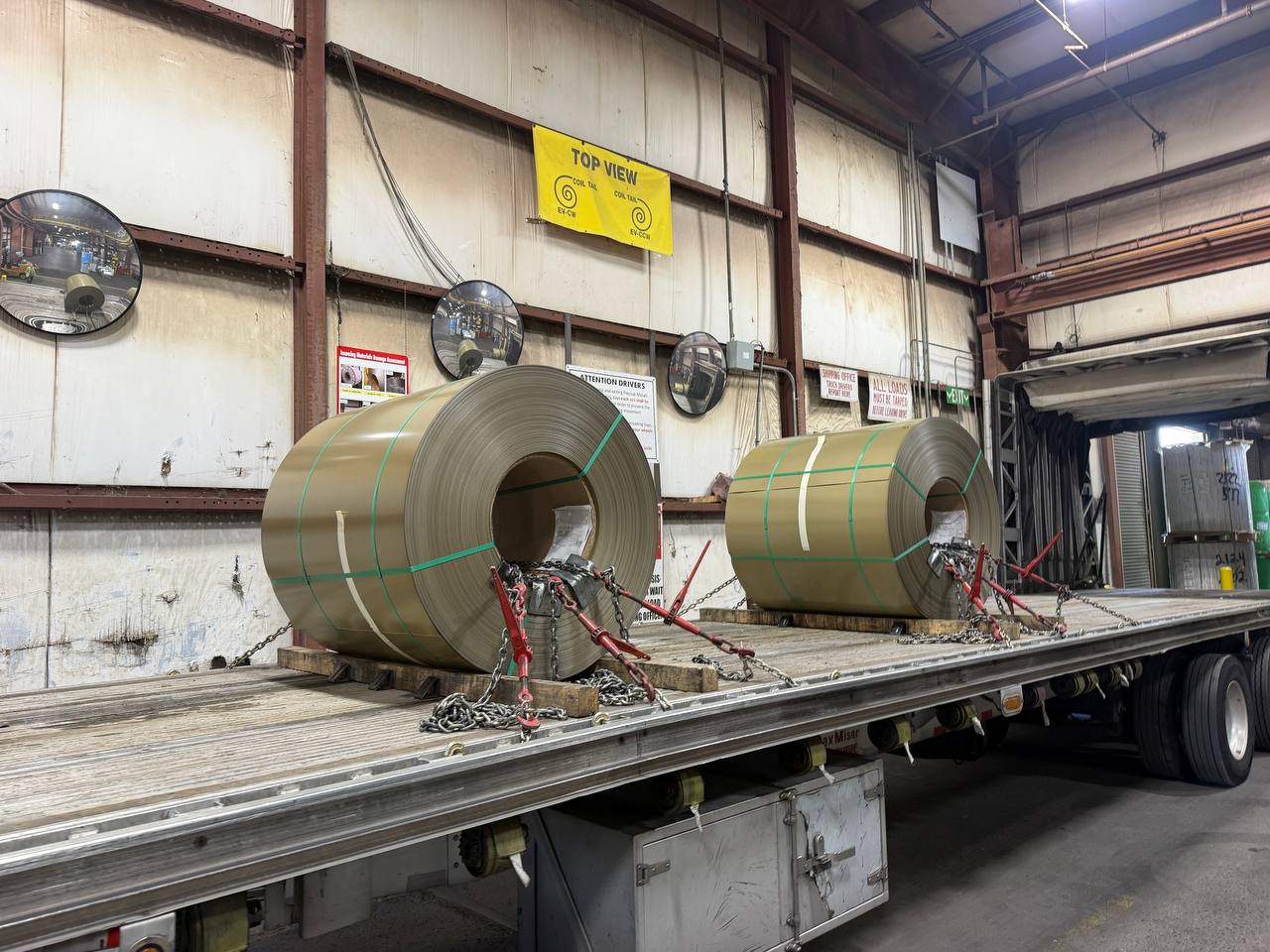 Two steel coils chained on a trailer inside a steel mill