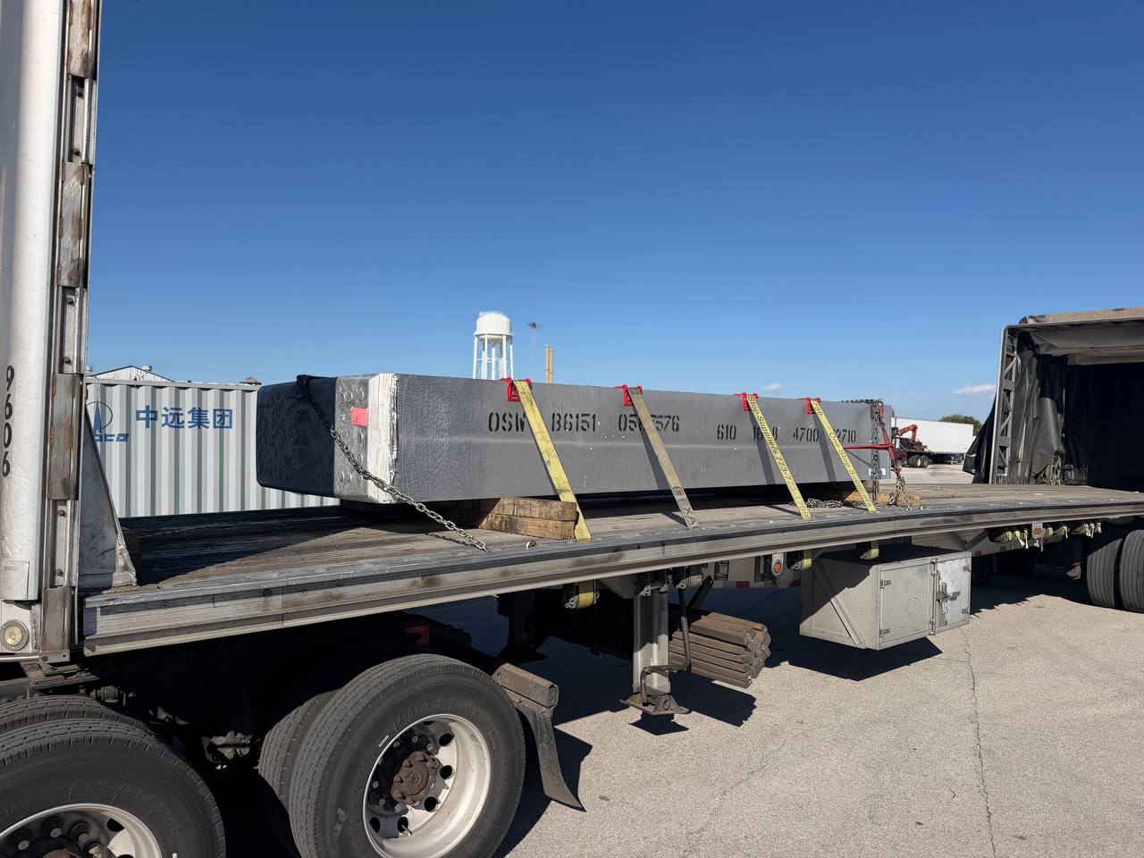 Large steel block chained and strapped on a Conestoga trailer